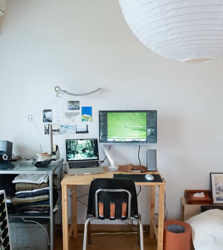 White-walled 1-person home office featuring a wood-tone desk, presenting a clean and compact atmosphere
