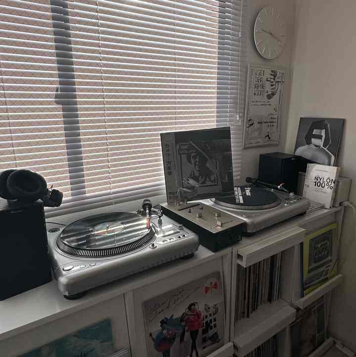 White and gray toned living room featuring vinyl record players and LP collection with a calm retro music listening atmosphere