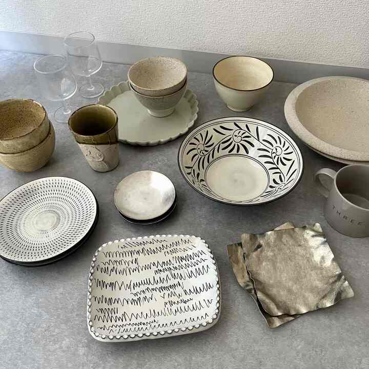 白とナチュラルカラーのキッチン空間、様々な模様と質感の和食器がモダンでシンプルに配置された印象的なインテリア