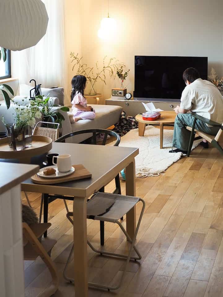 Natural and white toned living room featuring beige sofa and wooden coffee tables in cozy family space