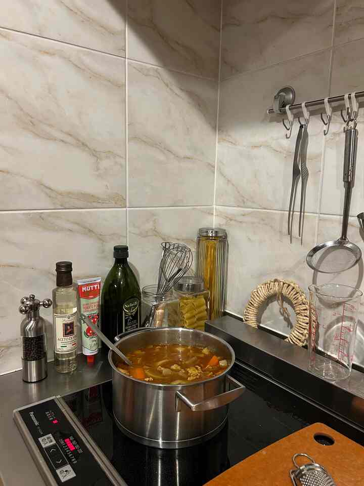 シルバーの調理器具とステンレス鍋が配置された清潔感のあるキッチンコーナー