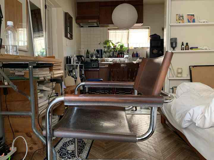 ナチュラルカラーの温かみある色調とヴィンテージ家具が配置された、居心地の良いリビングとキッチンの空間