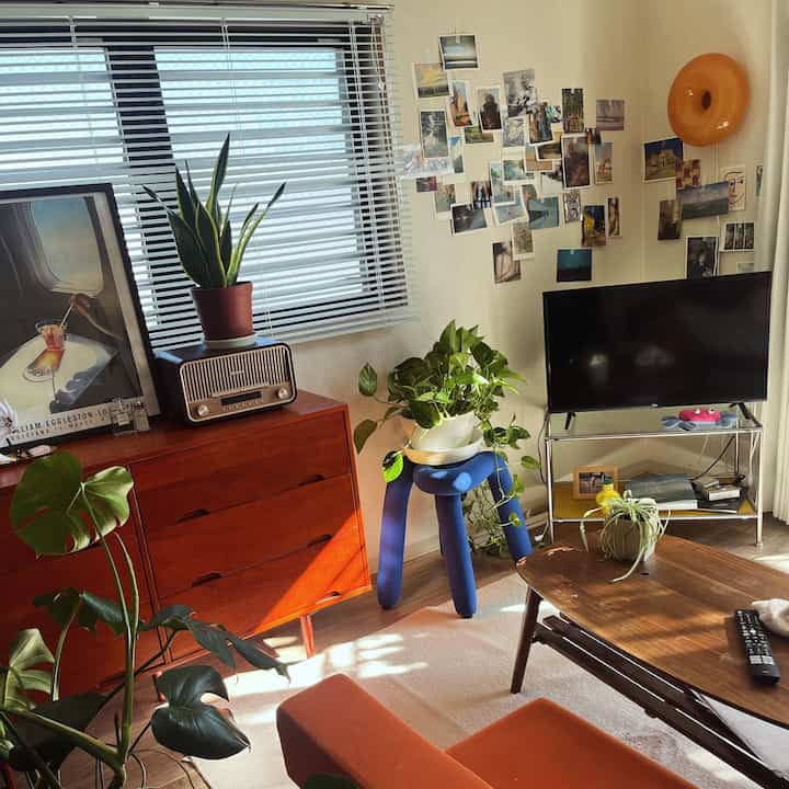 Warm-toned 8-tatami living room featuring wooden dresser, sofa, and plants creating cozy atmosphere