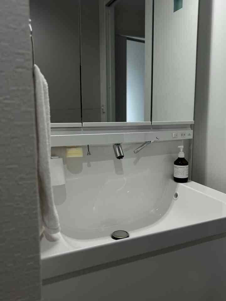 白を基調としたシンプルな洗面台の空間、清潔感と整った雰囲気のあるインテリア