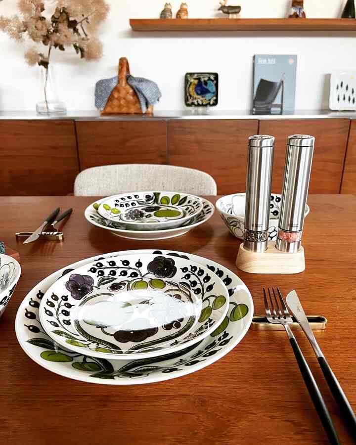 温かみのある木目調のダイニングテーブルに飾り皿と電動ソルト＆ペッパーミルが配置されたホテルライクな空間