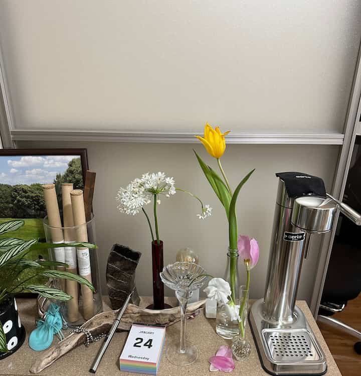 A simple modern desk with colorful tulips and flowers featuring a stainless steel carbonator, creating a natural and fresh atmosphere