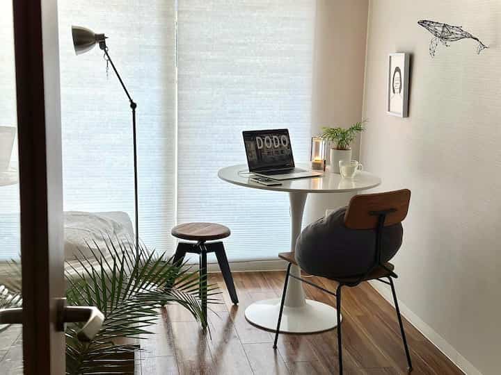 White and dark brown toned dining room featuring a round dining table and floor lamp with a natural and clean atmosphere