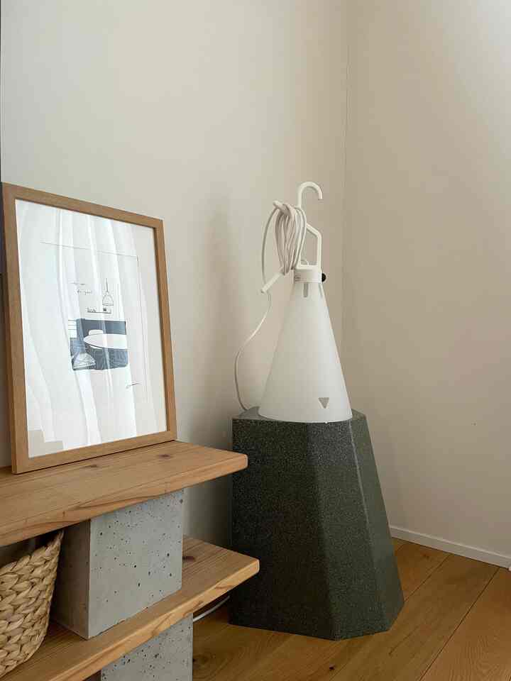Natural modern corner space with white lamp and gray concrete stool