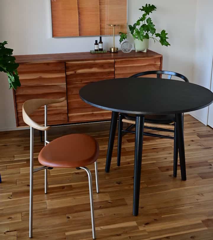 Dining room with brown wood tones and black matte table, featuring natural modern style ambiance