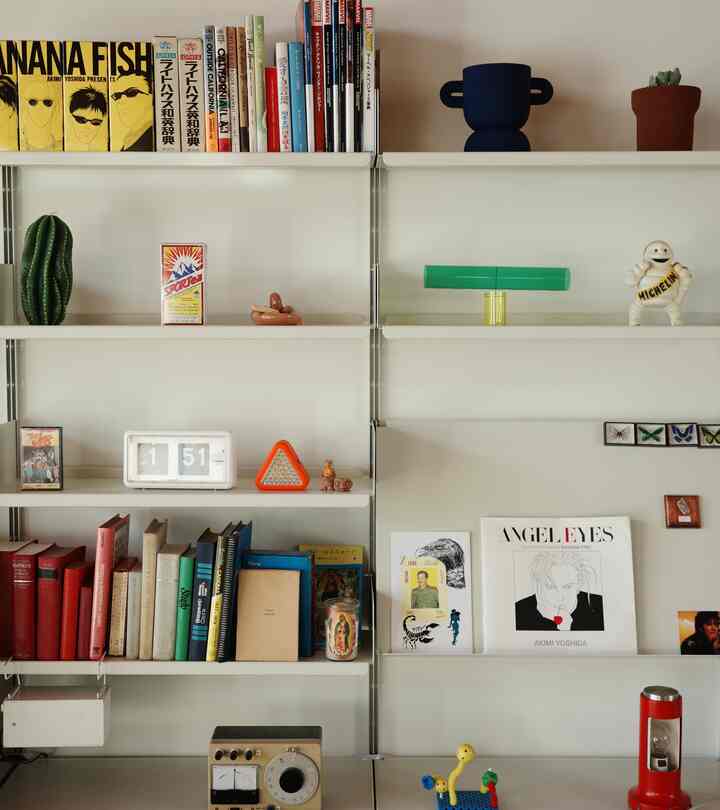 A Nordic style cozy study space with white walls and shelves featuring various books and decorative items