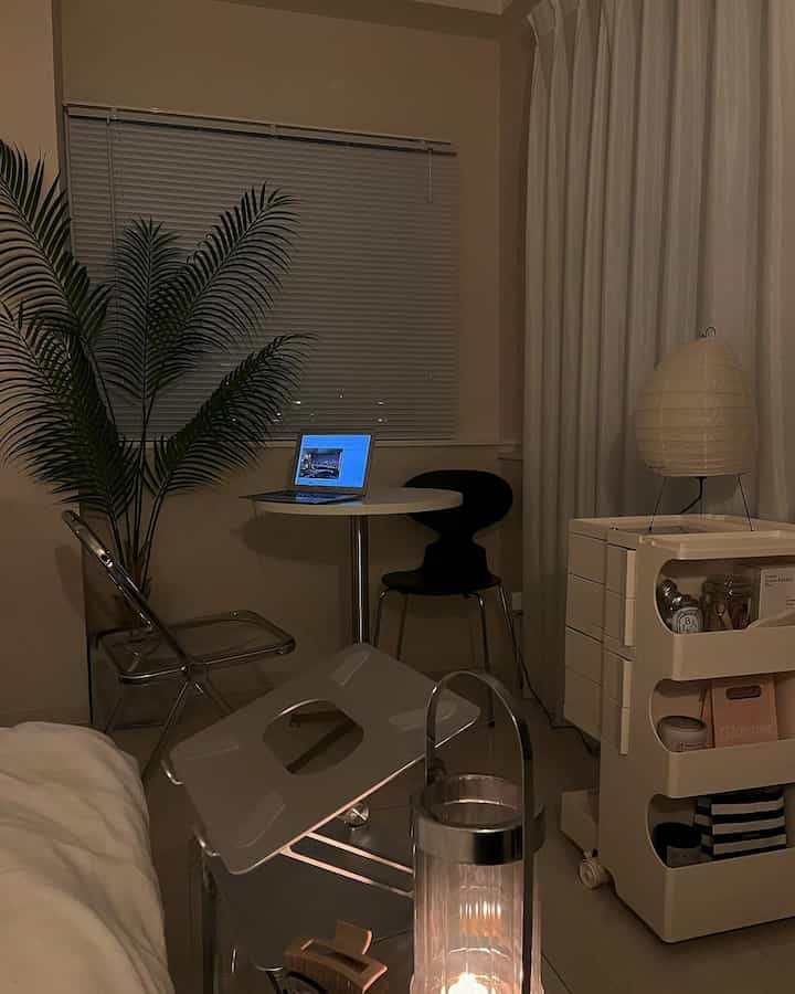 ホワイトとミニマルな色調のワンルームのホームオフィス空間、透明な椅子と植物が調和した落ち着いた雰囲気