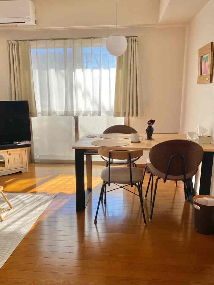 ナチュラルとホワイトの色調のダイニング、木製のテーブルとインダストリアルチェアが配置された雰囲気のある空間