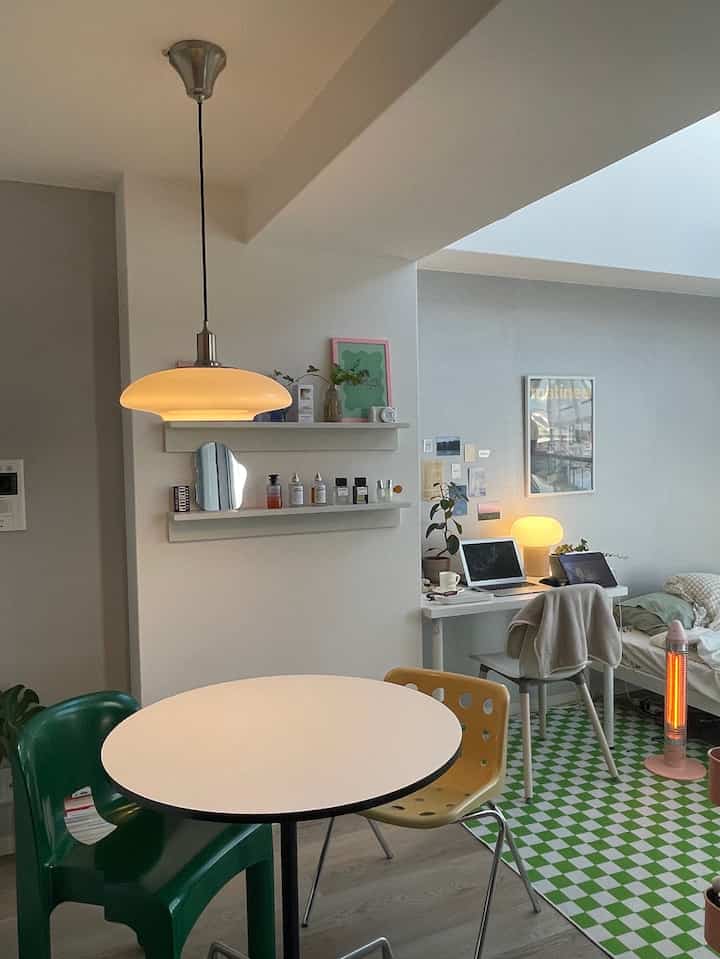 Simple small single household room with green checkered floor and yellow chair, featuring a home office and home cafe elements in a cozy ambiance