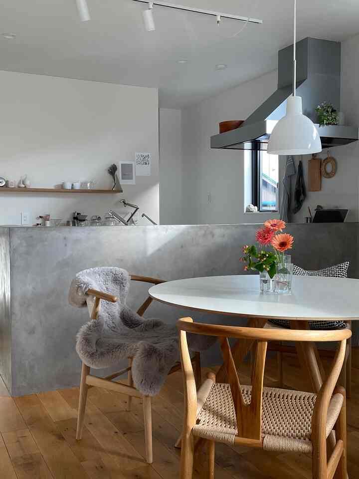 Nordic-style dining room with white walls and wooden furniture, featuring a round dining table and Y chairs creating a natural atmosphere