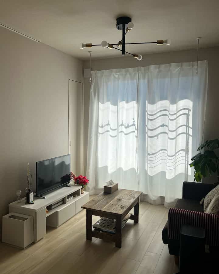 Nordic style living room with white and wood tones, featuring natural light and simple minimalist decor