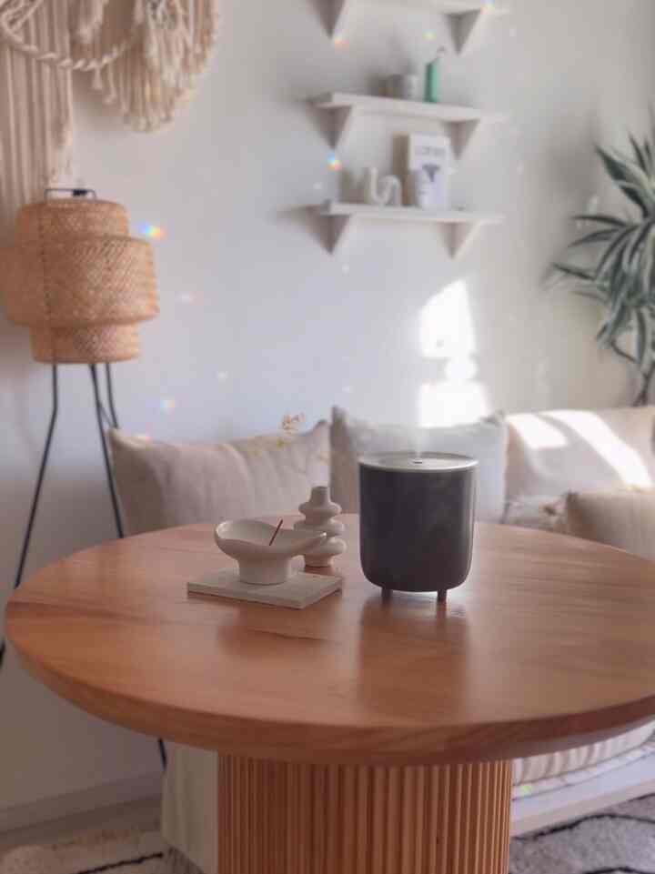 柔らかなベージュと木目調のリビング、中央にコードレス加湿器が置かれた丸形ダイニングテーブルがある雰囲気のあるインテリア