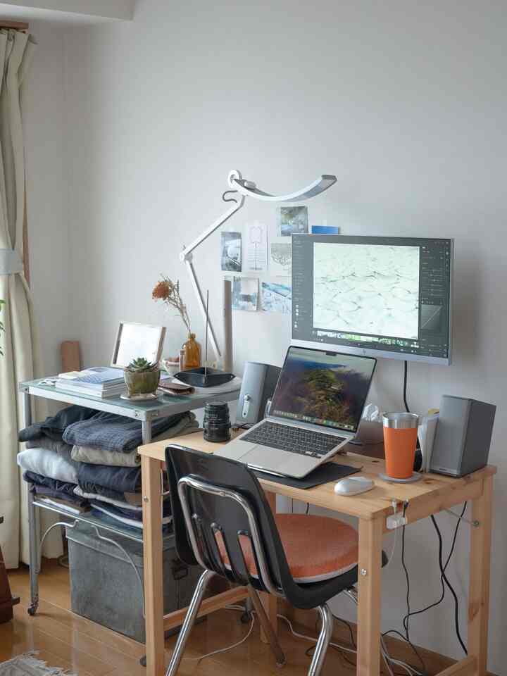 ナチュラルな色調のコンパクトな一人暮らしホームオフィス、木製デスクとモニター、整頓された収納棚が配置された清潔感のある作業空間