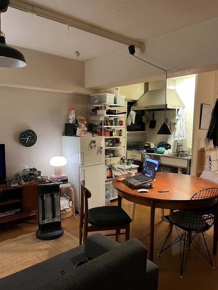 ベージュの色調が落ち着く、コンパクトな二人暮らしのキッチンダイニング。木製のテーブルとホームオフィスが調和した印象的な空間