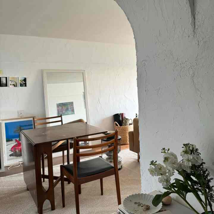 ナチュラルな色調のダイニング、折りたたみ式の木製テーブルとダイニングチェア2脚が配置された温かみのある空間