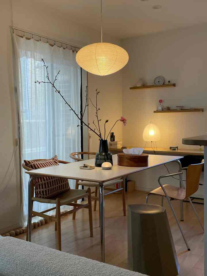 Natural wood tone and white dining room featuring modern dining table and ambient lighting creating a cozy atmosphere