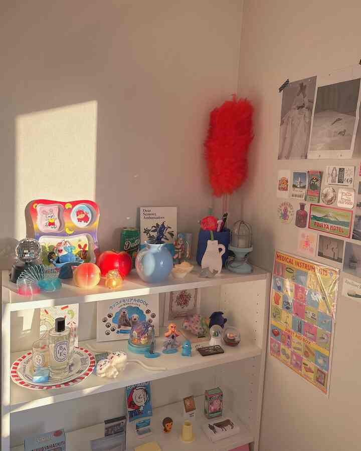 Room with white bookshelf bathed in warm natural light, featuring various collectibles and wall decorations creating a cozy atmosphere