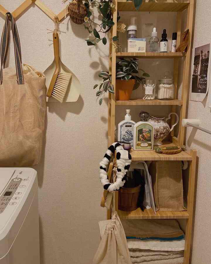 ナチュラルな色調のバスルーム空間、木製の棚と洗濯機が配置された清潔感のある収納アイデアが感じられるインテリア