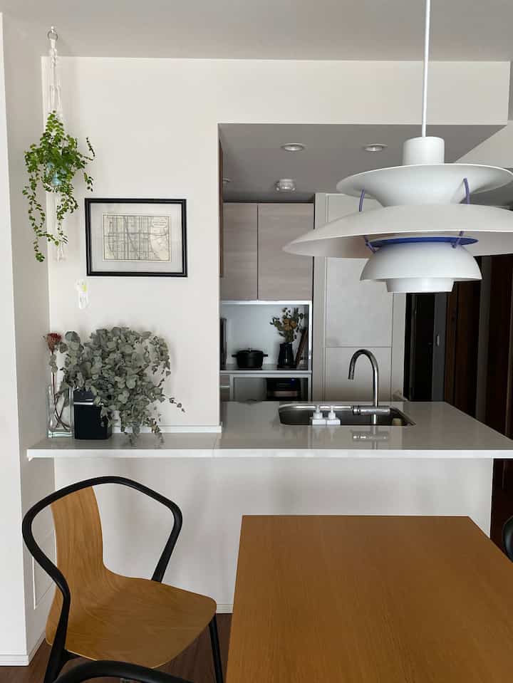 白を基調としたキッチン、木目調のダイニングテーブルが配されたシンプルで自然な雰囲気のインテリア