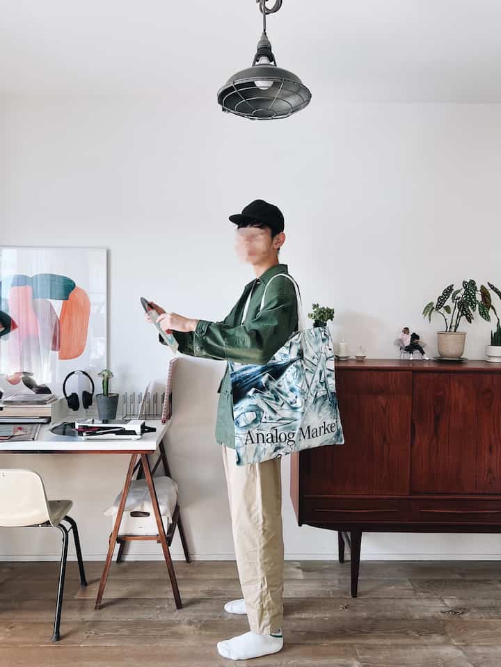 White-walled workspace with wood tone furniture, featuring record player and poster in a natural setting