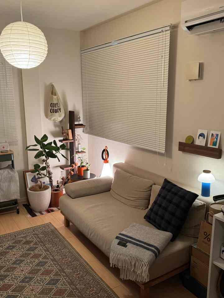 ベージュと木目調のリビング、ソファと多彩な照明が配置された雰囲気のある空間