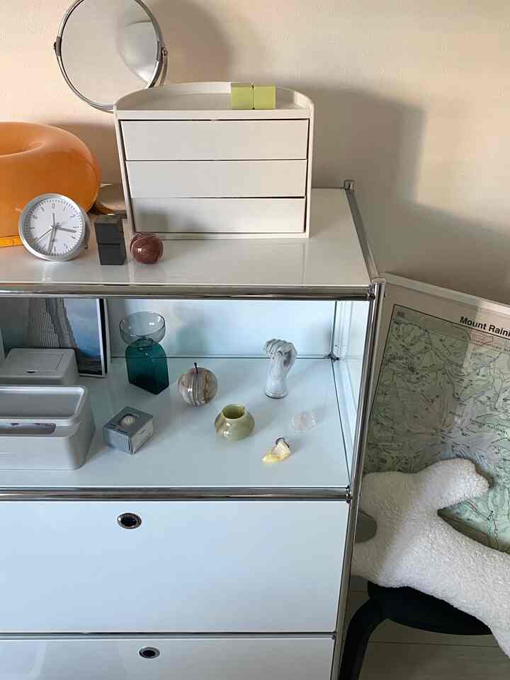 白を基調としたディスプレイ空間、IKEAのディスプレイラックとさまざまなオブジェが配置されたミニマルなインテリア