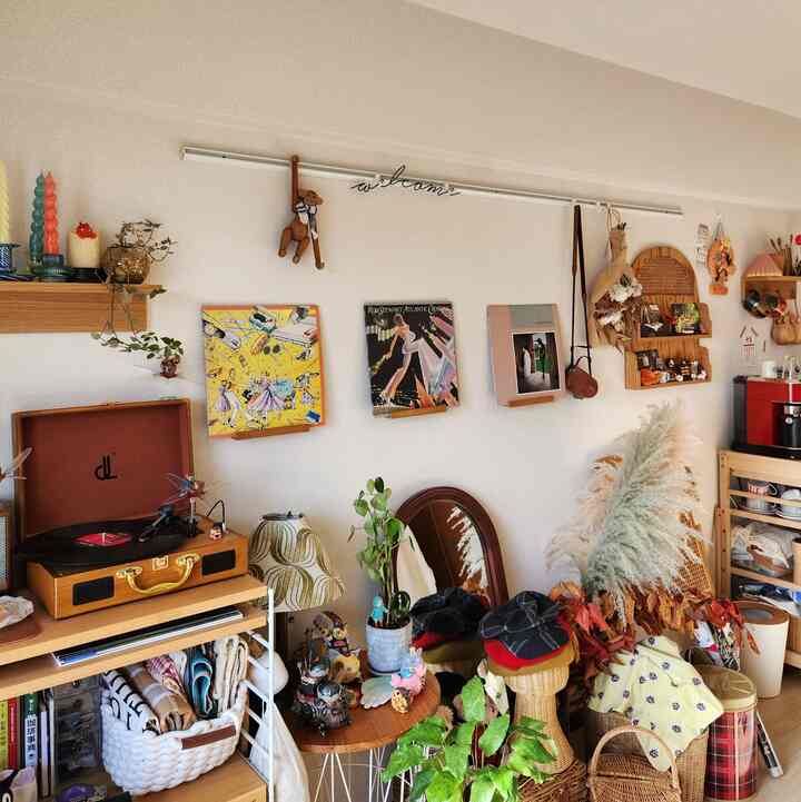 ナチュラルな木目調の壁とレトロなレコードプレイヤーが配置された印象的なワンルームインテリア