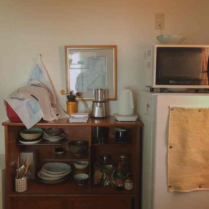 温かみのあるブラウンとホワイトのキッチン、ナチュラルなカフェ風インテリアにコーヒー用品が配置された印象的な空間