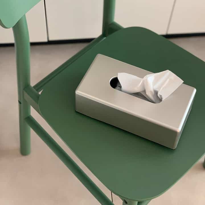 グリーンのダイニングチェアの上に置かれたマットシルバーのティッシュケースがあるシンプルモダンなインテリア