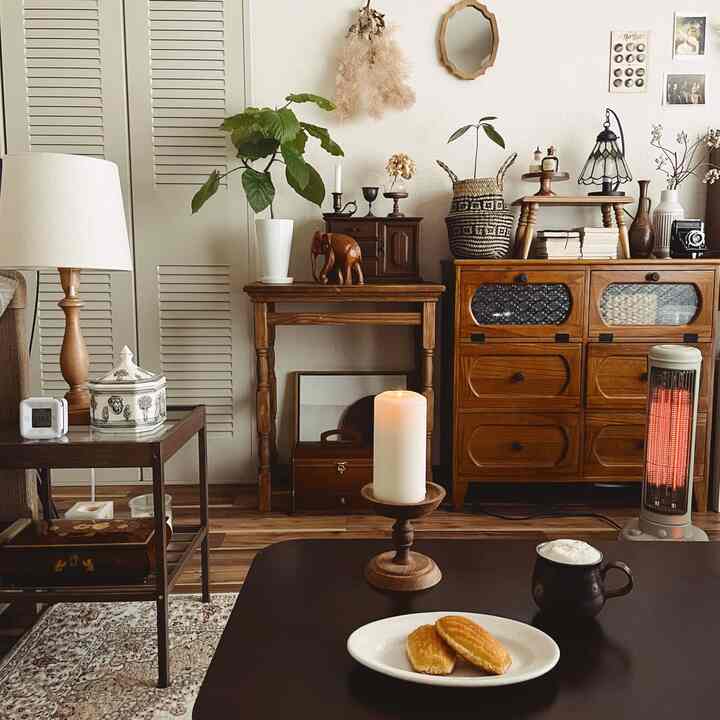 暖かみのあるウッドトーンとナチュラルな雑貨が配された居心地の良いリビング、コーヒーテーブルにマグカップとマドレーヌが置かれている