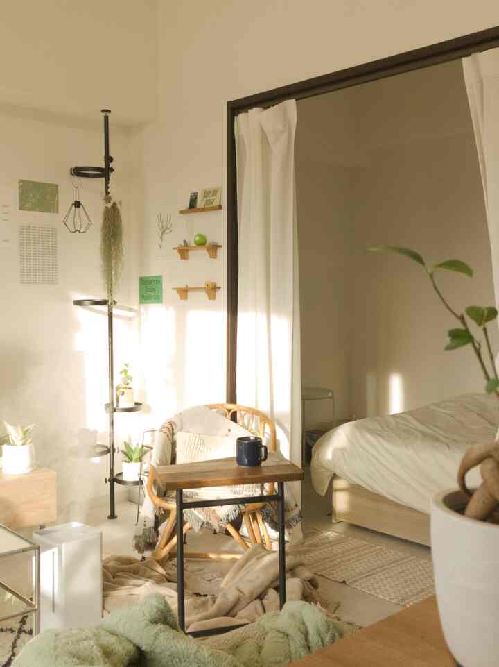 柔らかなホワイトとブラウンのトーンが特徴の1LDKの寝室兼リビング、自然素材の家具が温かみのある雰囲気を演出