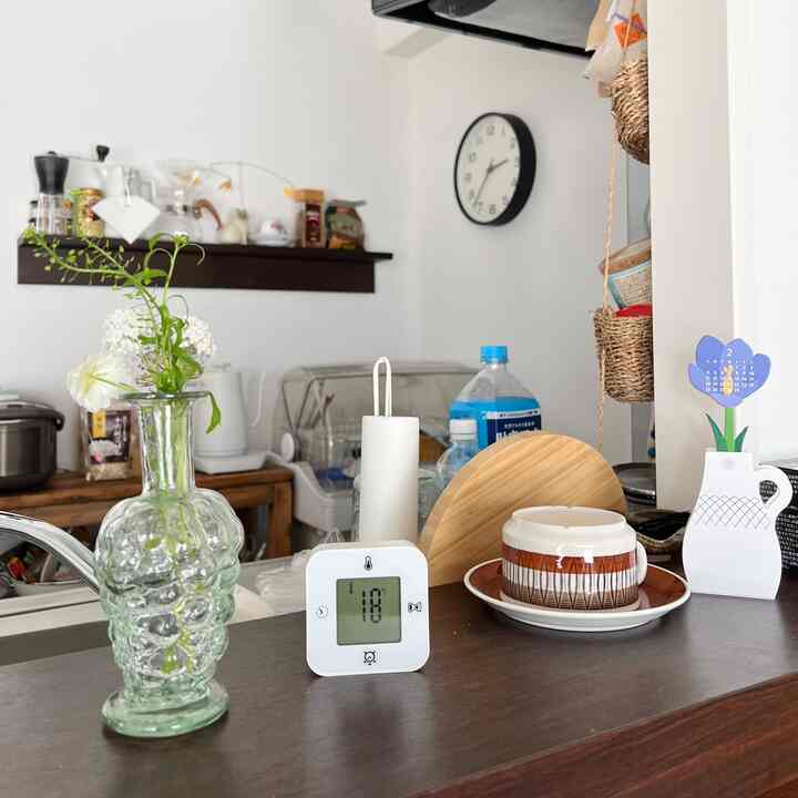 Natural wood tone kitchen with white walls featuring MUJI wall-mounted shelf and coffee accessories, cozy home cafe vibe