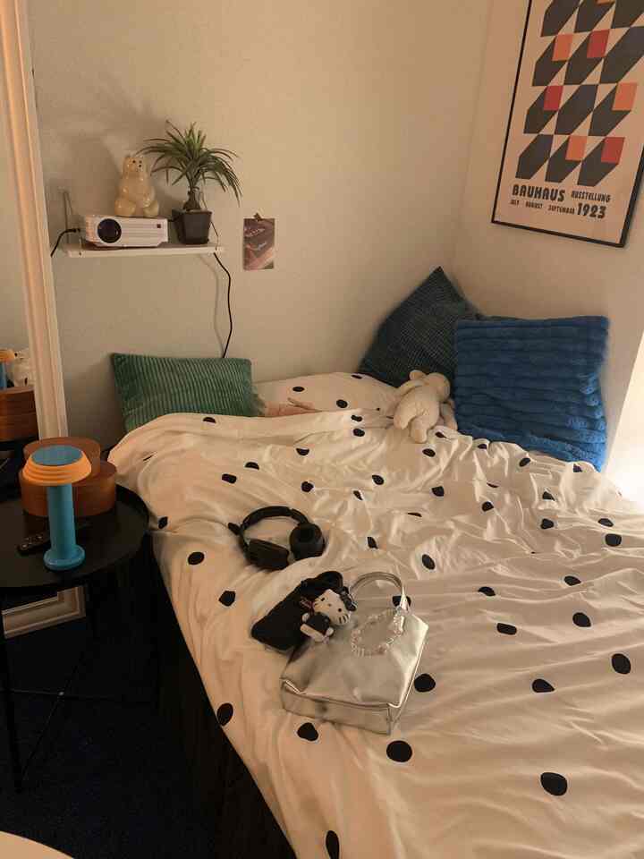 ホワイトとブルーのトーンの寝室、中央にベッドとクッションが配置された雰囲気のある空間