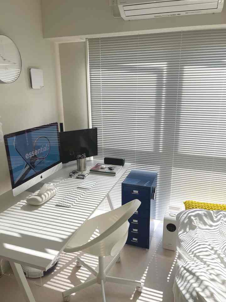 明るく清潔なホワイトトーンのワンルーム寝室兼ホームオフィス、机とブラインドの影が印象的なインテリア