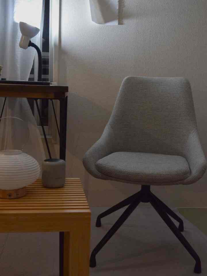 Light gray and wood tone workspace featuring a gray office chair and wooden desk in a cozy setting