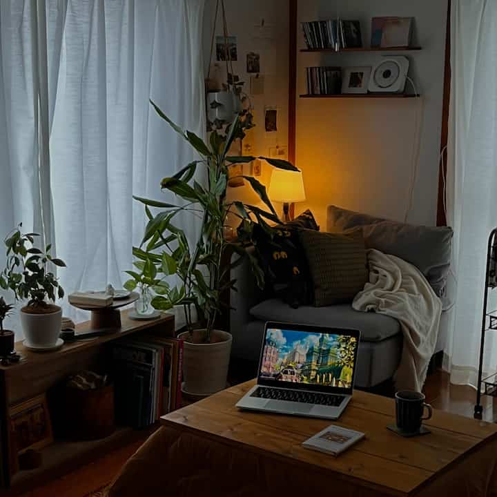 Cozy single household living room with bright white curtains and light brown wooden table, featuring plants and warm lighting ambiance