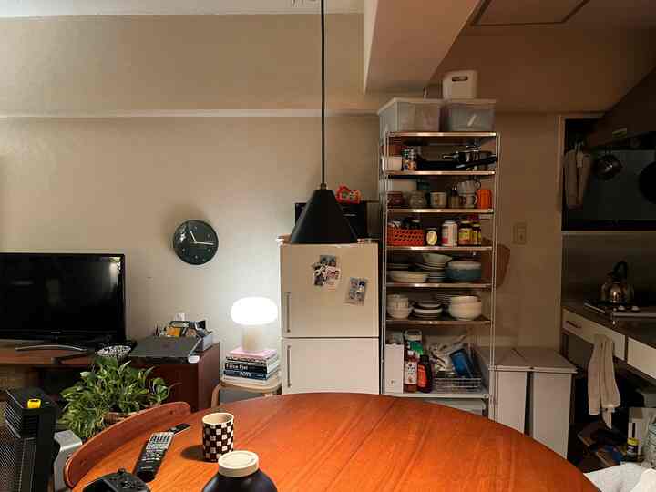 Beige-toned dining room centered around a wooden dining table with neat storage and lighting accents