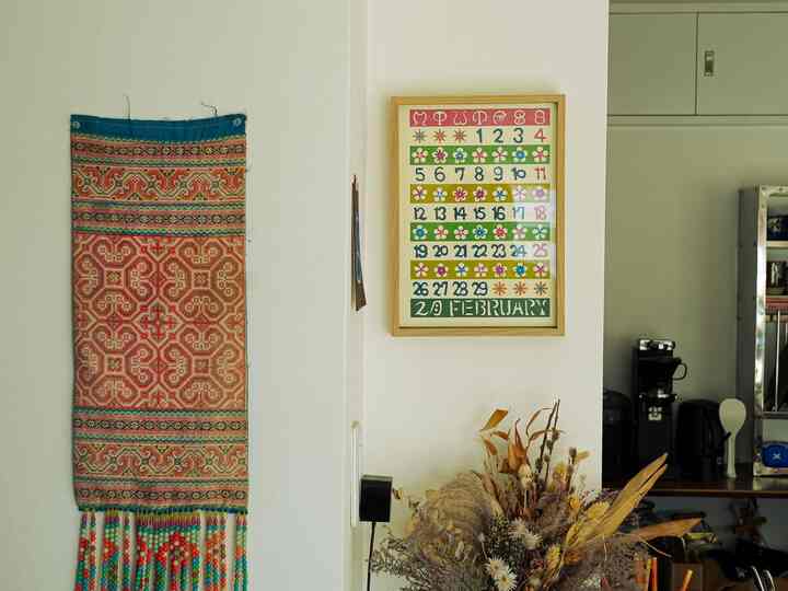 ナチュラルカラーの空間、民藝スタイルの額縁カレンダーと植物のオブジェが調和した温かみのあるインテリア