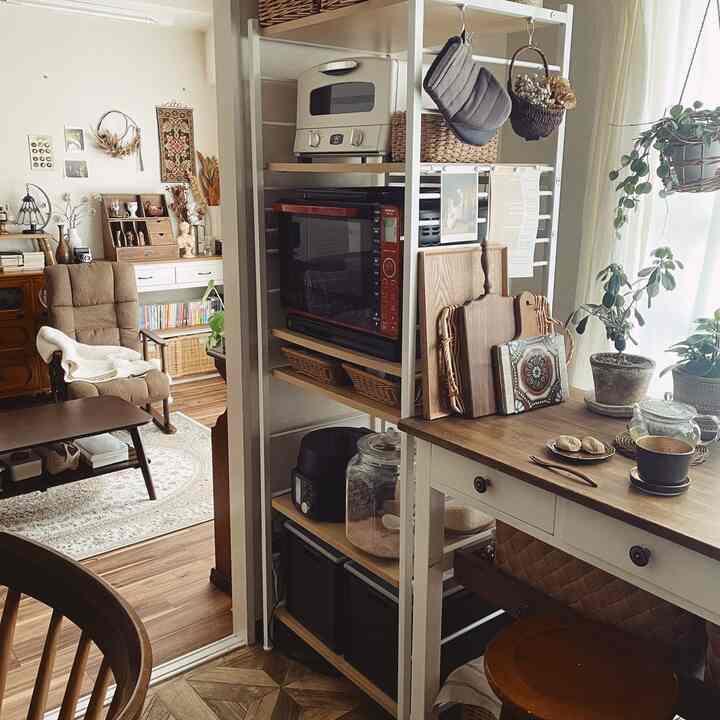 ウッドトーンとナチュラルカラーが調和したキッチンとリビング、レトロ家具とおうちカフェコーナーが配置された雰囲気のあるインテリア