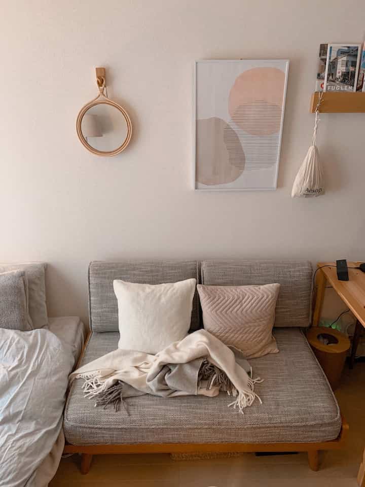 Natural-toned 1K single household living room featuring a gray sofa with beige cushions in a cozy setting
