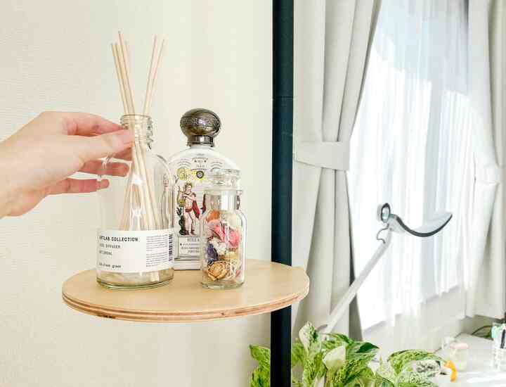 ライトグレーとナチュラルな色調のホームオフィス、木製トレイにディフューザーと花瓶が置かれた窓辺の雰囲気あるインテリア