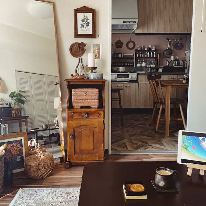 温かみのあるブラウン調の二人暮らしダイニング、木製家具と大きな鏡が配置された雰囲気のあるレトロなインテリア