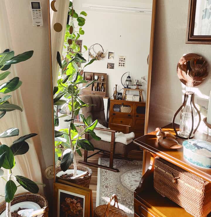 Warm brown toned retro living room featuring antique furniture and abundant plants creating a cozy atmosphere