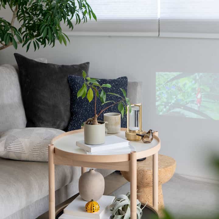 Natural-toned living room featuring a gray sofa and wooden side table with a calm atmosphere
