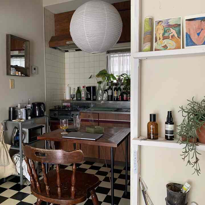 Light ivory walls and natural wood-tone kitchen featuring wooden dining table and chair, pendant lighting creating a cozy space