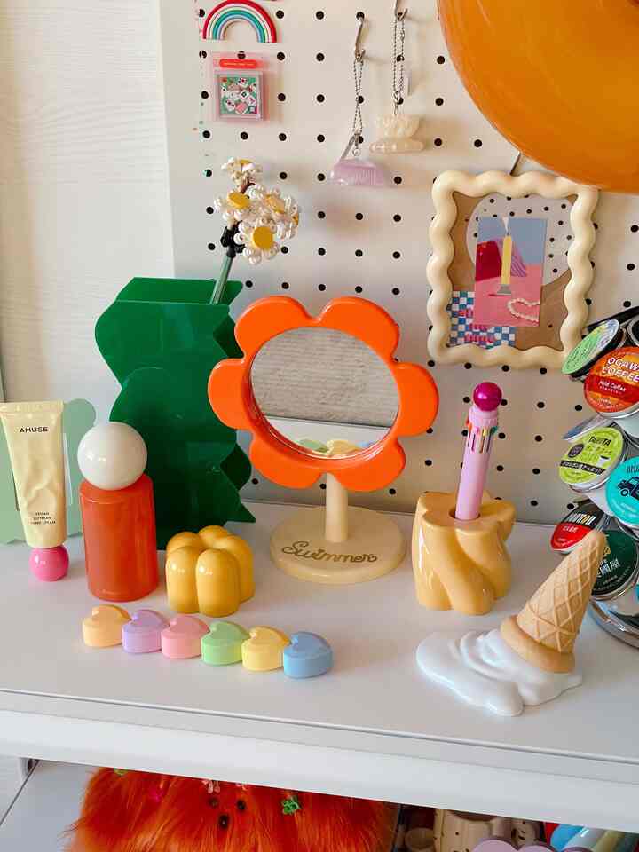 オレンジと緑を基調とした花形のミラーとカラフルな小物が置かれた可愛らしいレトロスタイルの化粧台